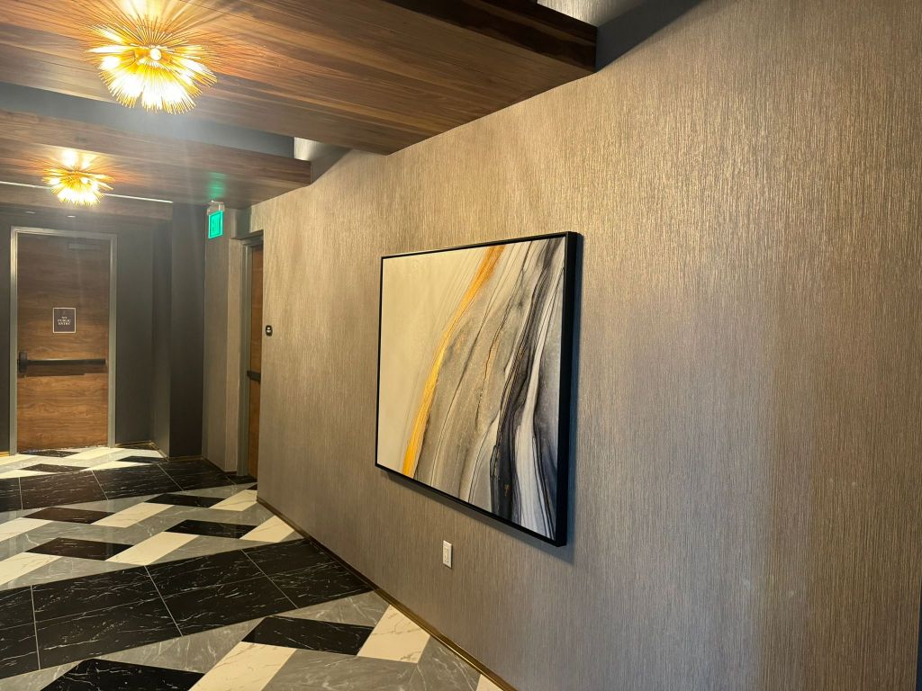 Textured champagne wallcovering in a hospitality corridor